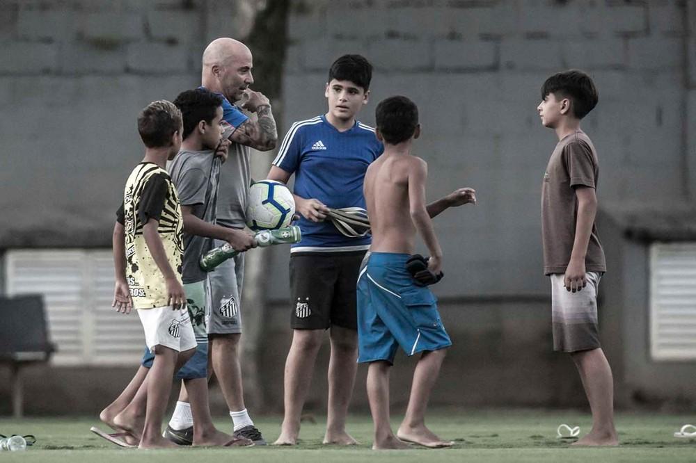 Crianças que viam treino do Santos em árvore são convidadas por Sampaoli para jogar bola no CT
