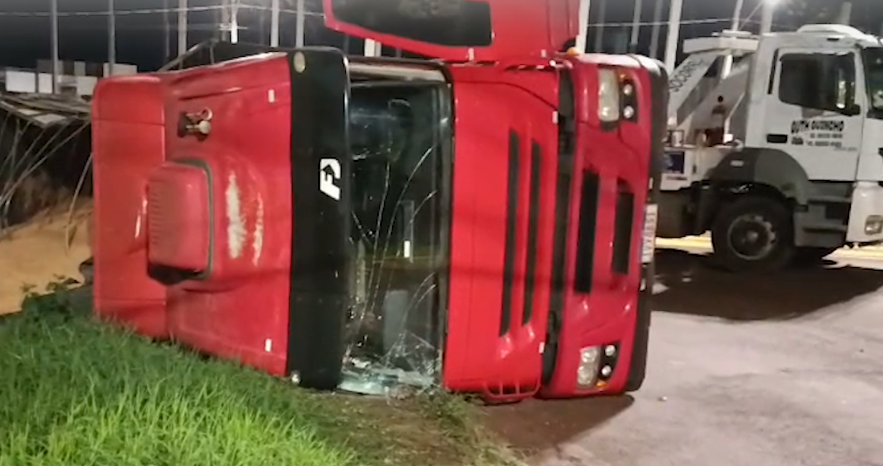 Caminhão bitrem carregado com soja tomba em rotatória