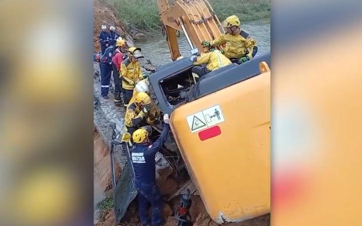 Homem fica preso por 9 horas após retroescavadeira cair em ribanceira